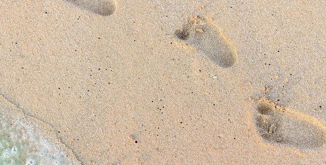 Empreintes de pieds de bébé dans le sable 