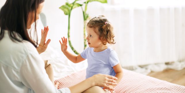 petite fille apprenant le langage des signes avec sa maman