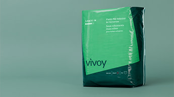 Grünes Paket der Vivoy Pants für Herren steht vor grünem Hintergrund.