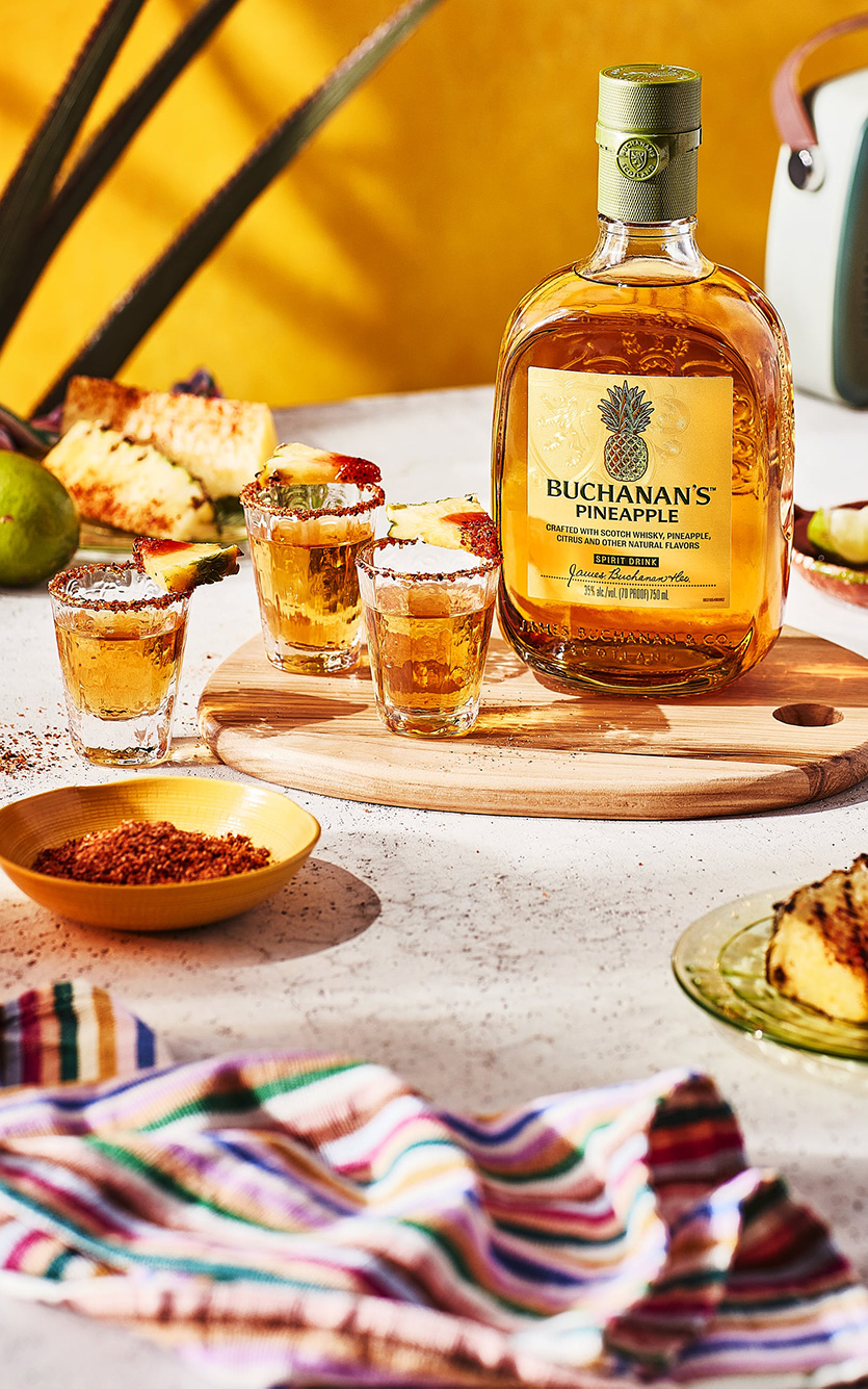 3 chilled shots of Buchanan's Pineapple rimmed with Chamoy and Tajín and served with a lime wedge
