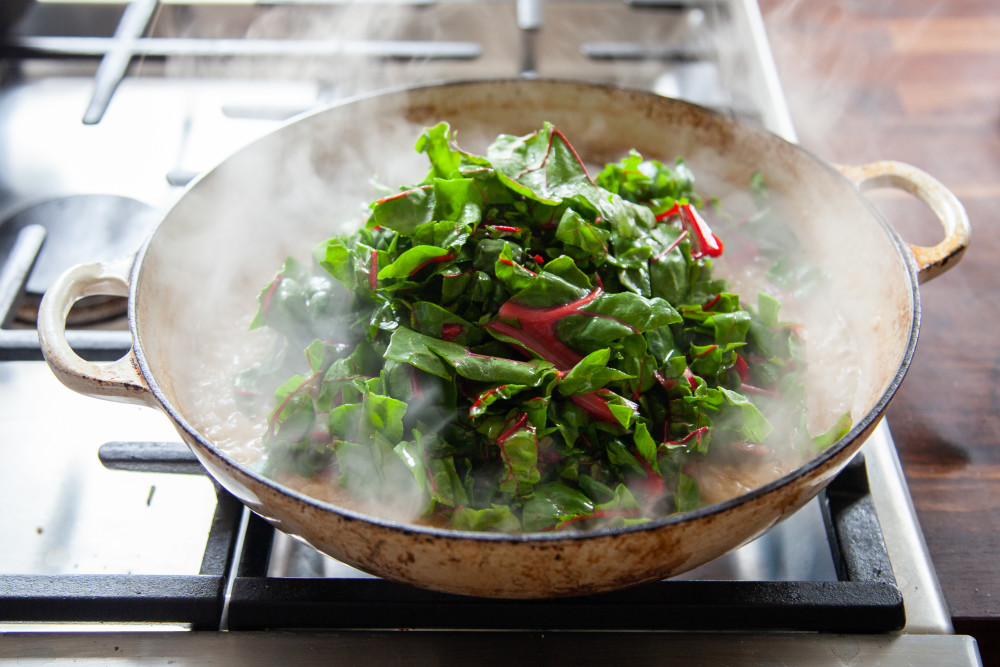 Pile chopped chard on top, squeeze charred lemons over the greens, and fold in until greens are wilted.