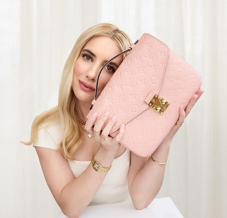 Emma Roberts in a white dress with a pink Louis Vuitton empreinte Pochette Metis.