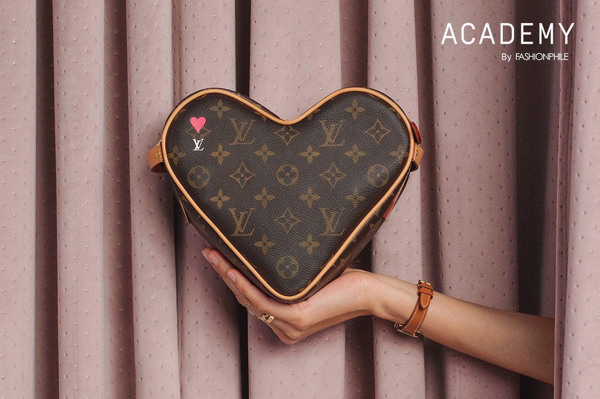 a woman's arm holding a Louis Vuitton Monogram Game On Coeur heart shaped bag