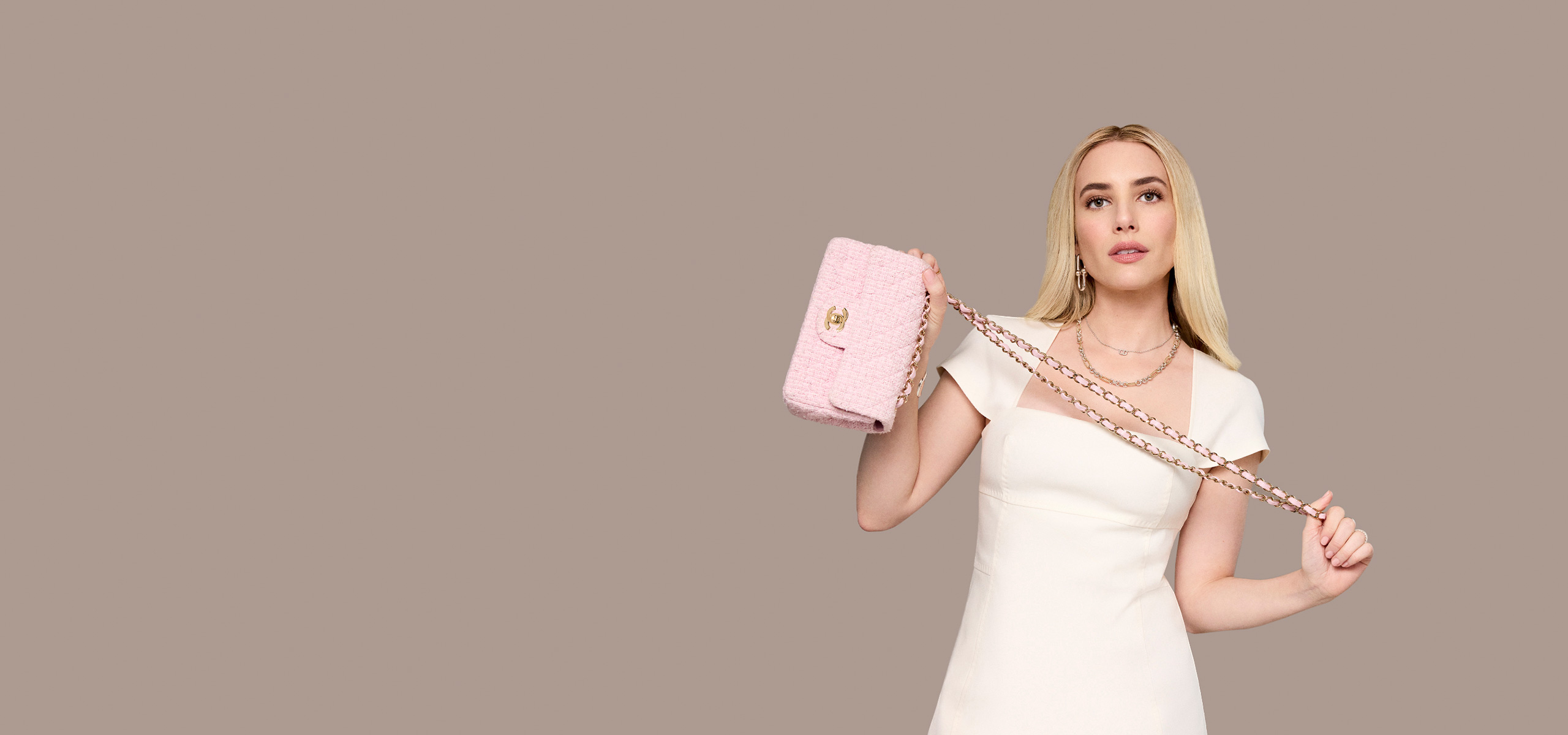 Emma Roberts in a white dress holding a pink tweed Chanel mini rectangular flap