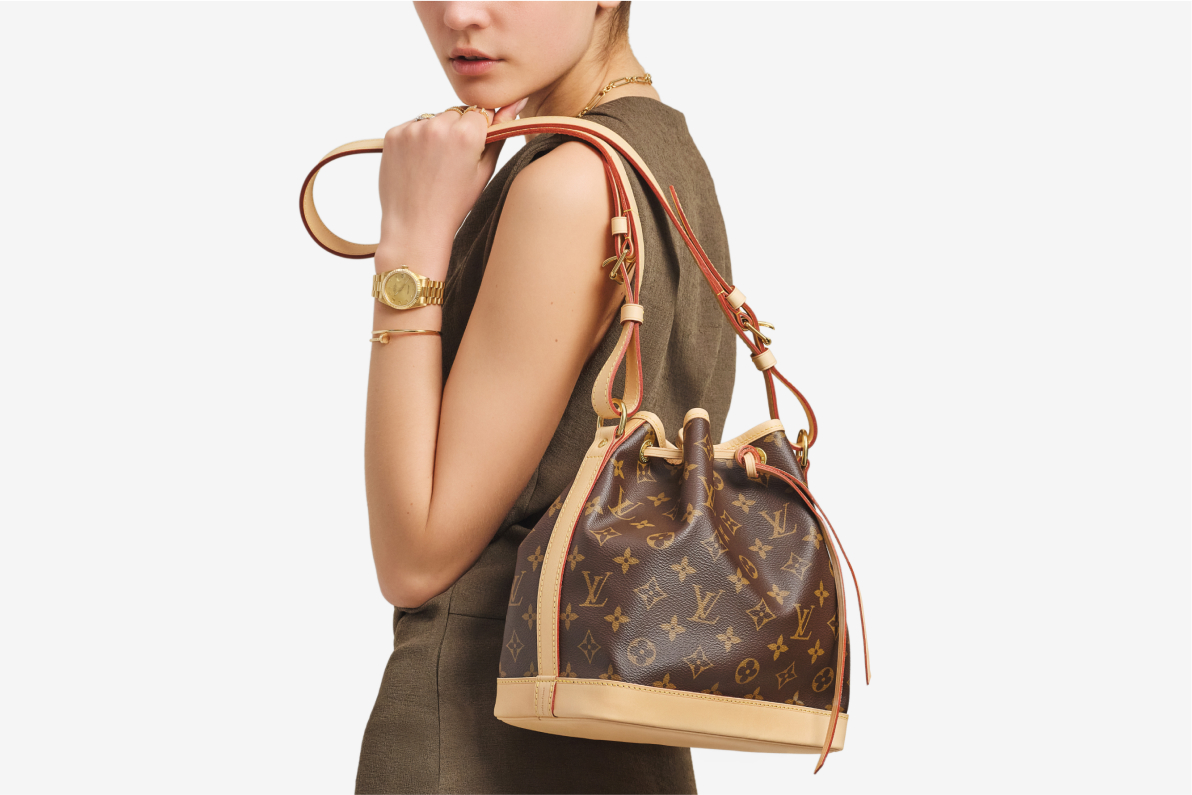 a woman wearing a green sleeveless dress holding a Louis Vuitton Monogram Noe