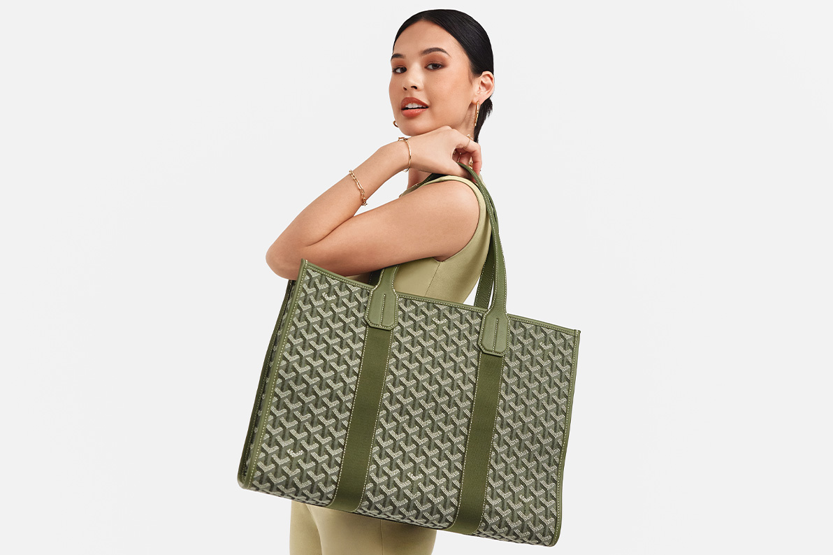 a woman in a green matching pants and sleeveless top holding a green GOYARD Goyardine Villette Tote