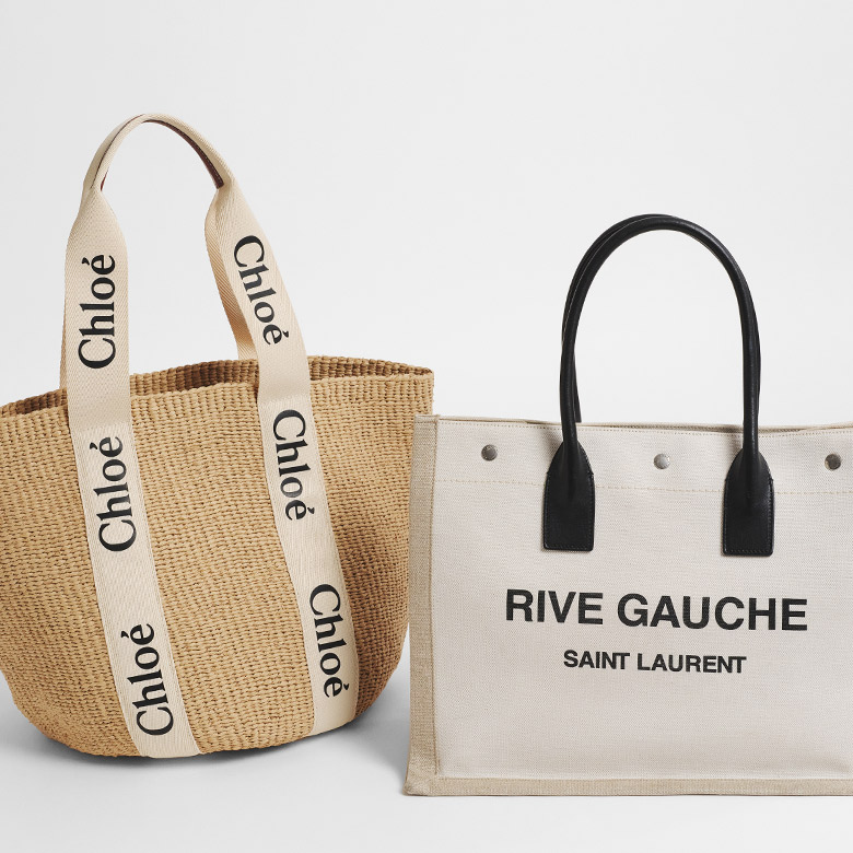 one CHLOE Raffia Large Woody Tote sitting next to one beige SAINT LAURENT Linen Calfskin Rive Gauche Tote