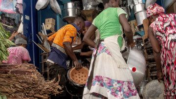 Kochende Frau mit Kind in Ghana 