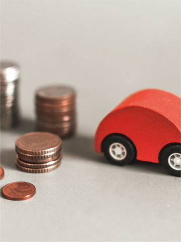 rotes Spielzeugauto mit Münzgeld