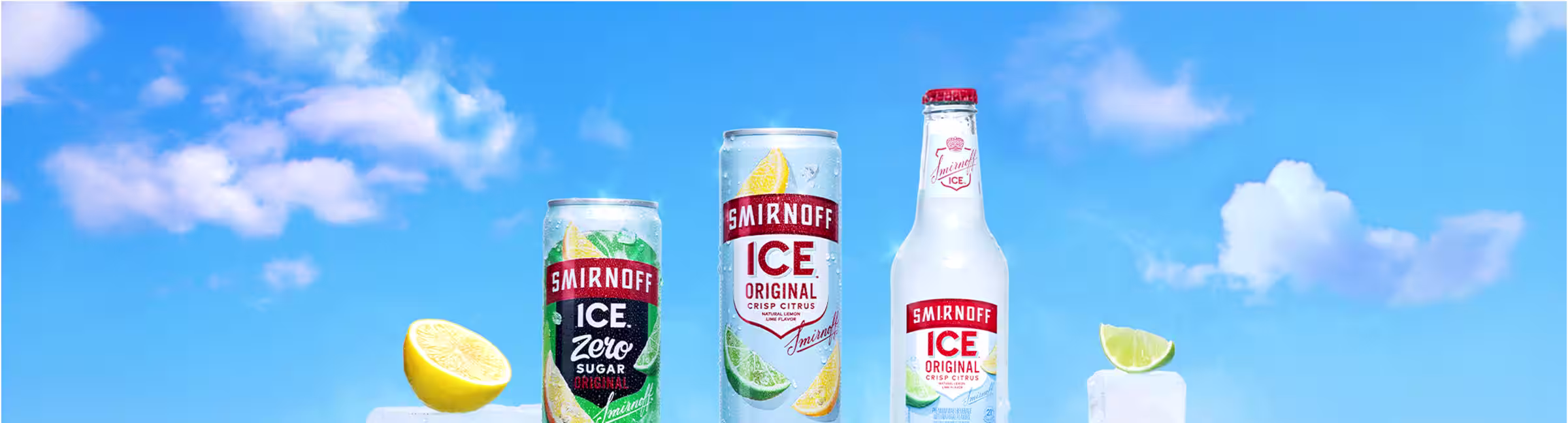 Cans of Smirnoff Ice Original on Ice blocks, against blue sky background with a couple clouds.