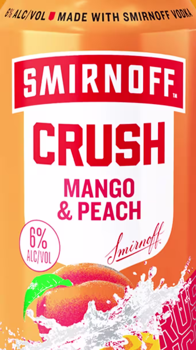 Close-up of a Smirnoff Crush Mango & Peach can with bold red text. Features "6% ALC/VOL" and "Made with Smirnoff Vodka" on a orange background, with peach imagery and splash effects.
