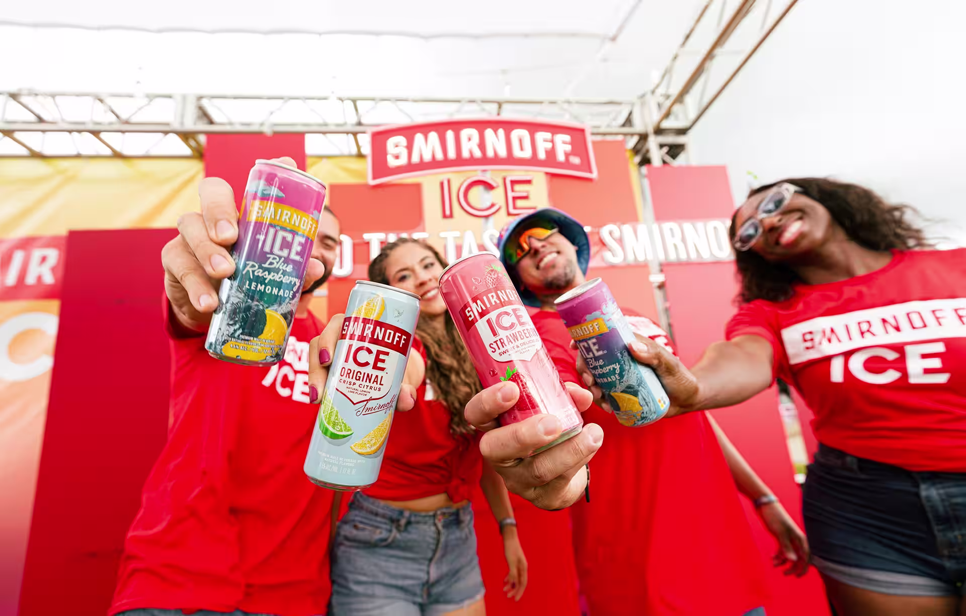 Four people holding Smirnoff Ice cans in their hands