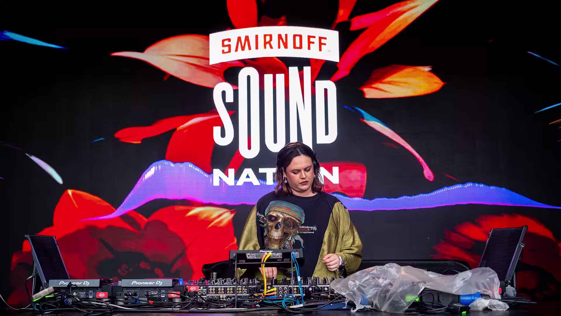 DJ performing on the Smirnoff Sound Nation stage with colourful screen graphics and the word Discovery.
