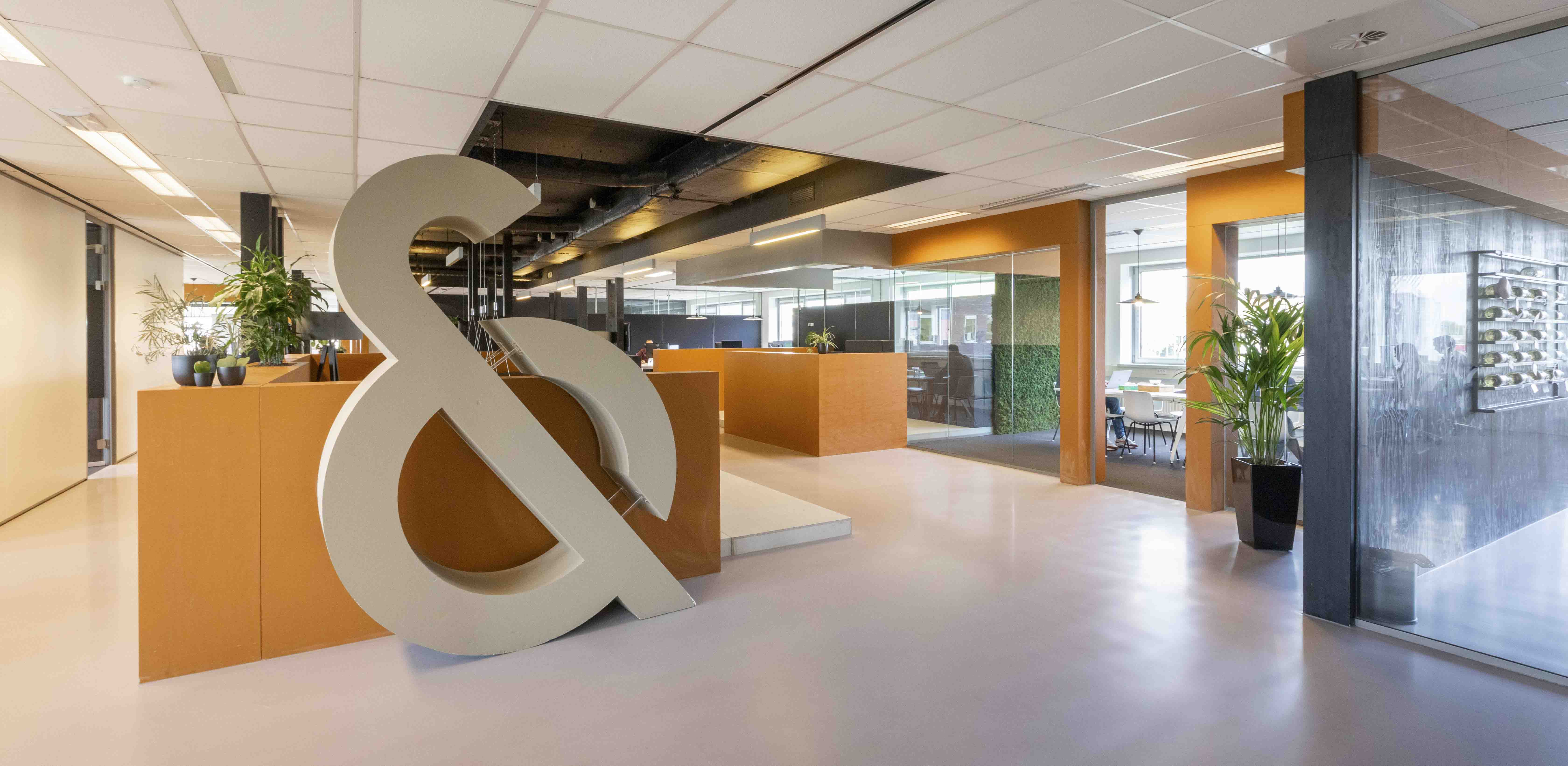 Overzicht van het kantoor met aan de linkerzijde de grote & en aan de rechterzijde een paar meeting ruimtes.