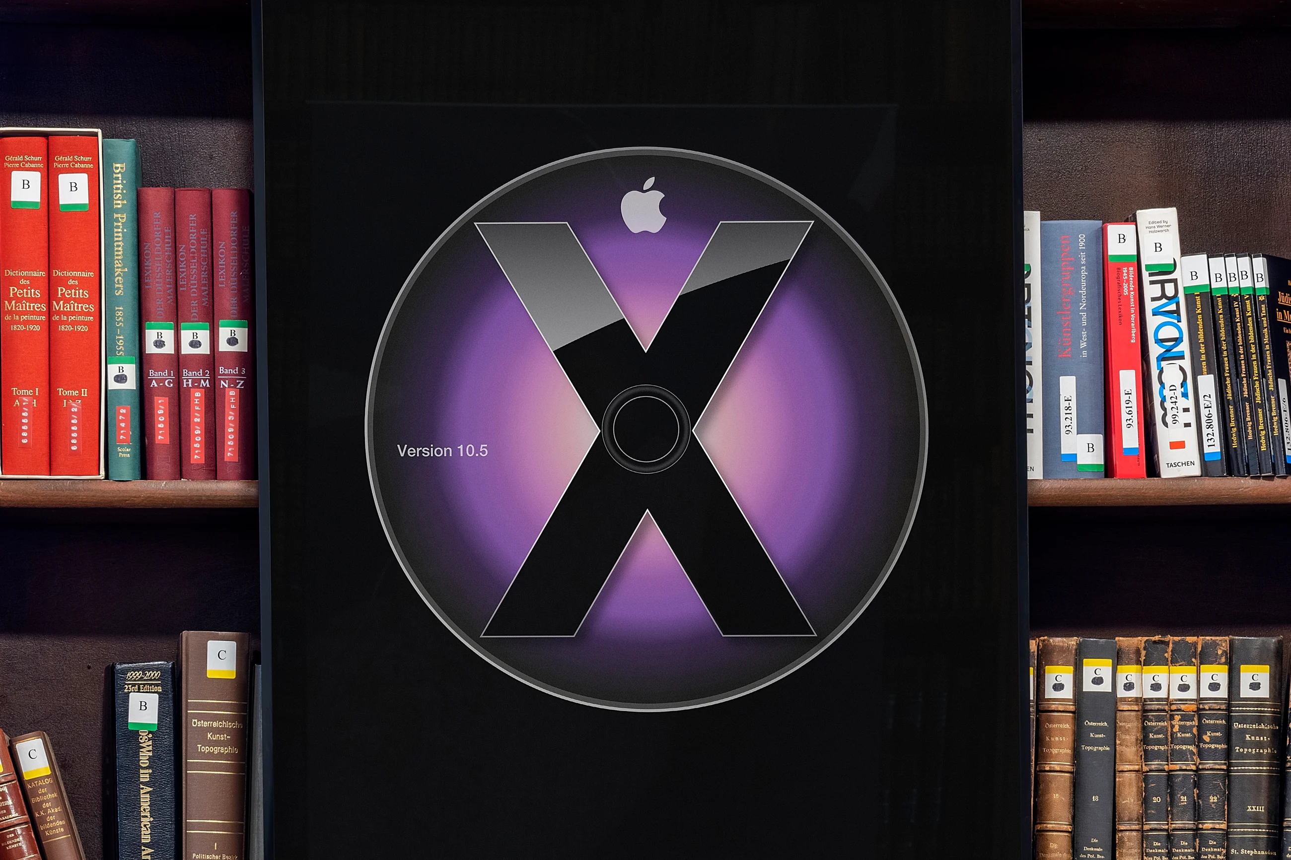 A large book cover displaying a CD with an Apple logo and the text Version 10.5 is set against a background of bookshelves filled with various books.