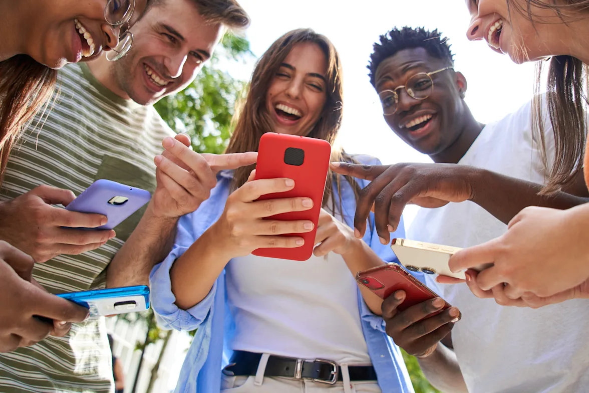 group smiling at phones in a circle