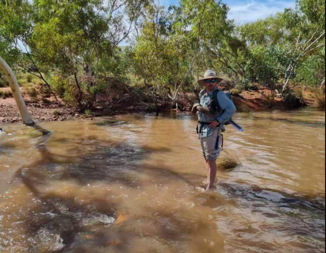 Man wearing hat standing in creek
