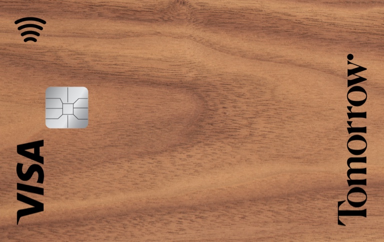 A Tomorrow Visa bank card with a wooden background.