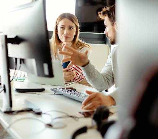 Image of professional looking at more than one screen at once, to represent a complex online process