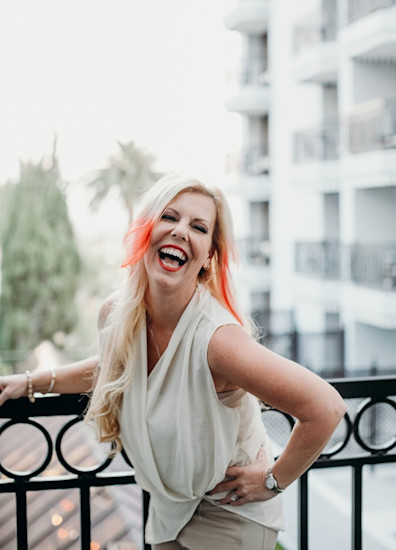 Portrait of Janelle Hoyland laughing on a balcony