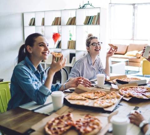 DDfB - Blog - 31 Corporate Perks Employees Really Want at Work - eating pizza