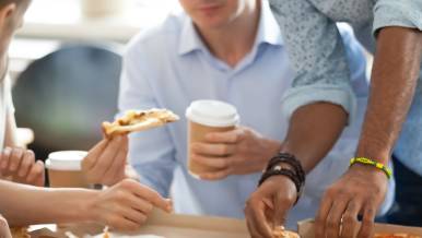 Coworkers indulging on an easy work lunch of pizza