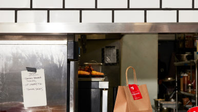 Counter at a restaurant with orders ready for dine-in and pickup with DoorDash