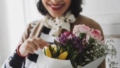 Woman in striped shirt holding bouquet of flowers