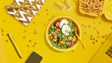 Salad bowl flanked by present, french fries and laptop