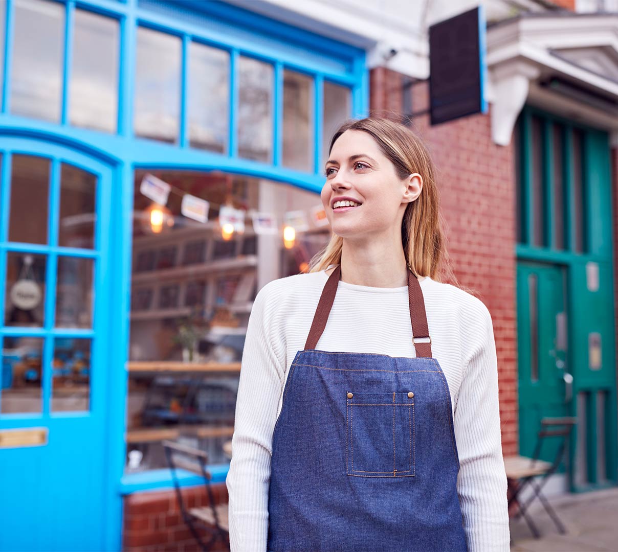 Mx Blog (US/CA/AU/NZ) - Restaurant Location Strategy: How to Choose Where to Open Your Business - Owner wearing apron on sidewalk