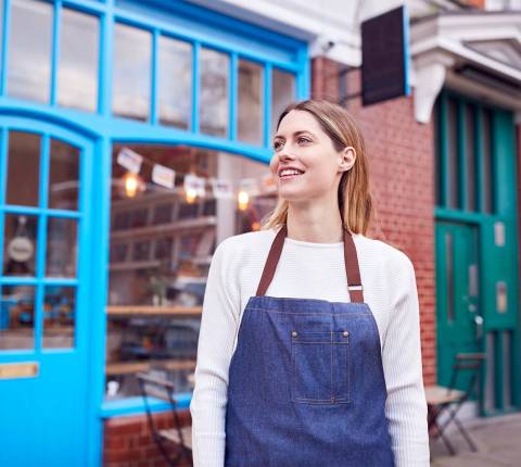 Mx Blog (US/CA/AU/NZ) - Restaurant Location Strategy: How to Choose Where to Open Your Business - Owner wearing apron on sidewalk