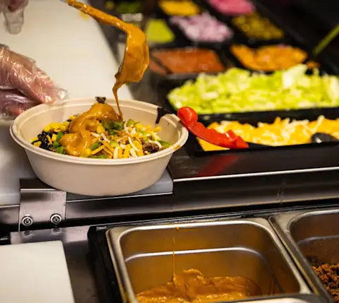 Burrito bowl being made at BarBurrito Canary District
