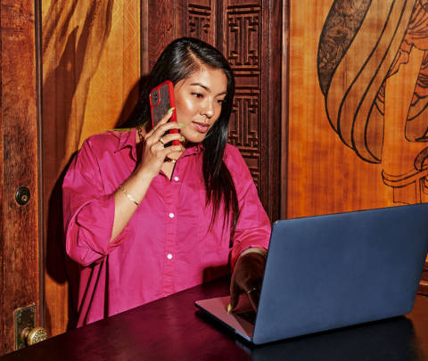 Person on phone with laptop