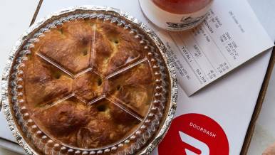 A pie with a bottle of wine ready to be delivered by DoorDash