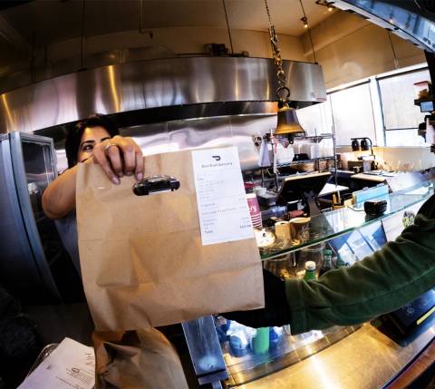 Mx Blog - Comparing In-House and Third-Party Delivery Services for Restaurants - Kitchen giving order bag to Dasher
