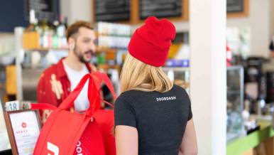 women picking up food order with doordash