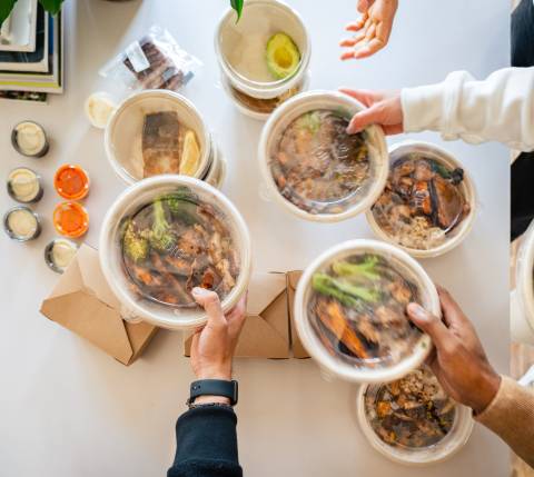 Employees grabbing food from a table