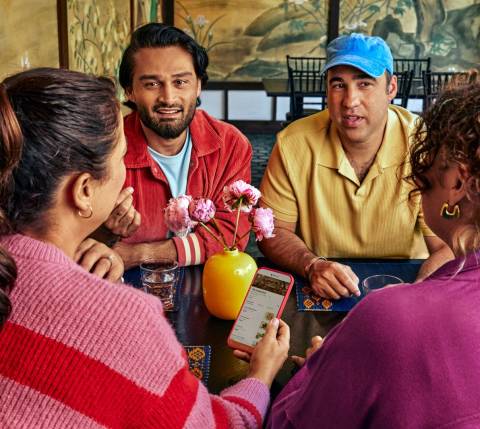 People gathered around table with phone 