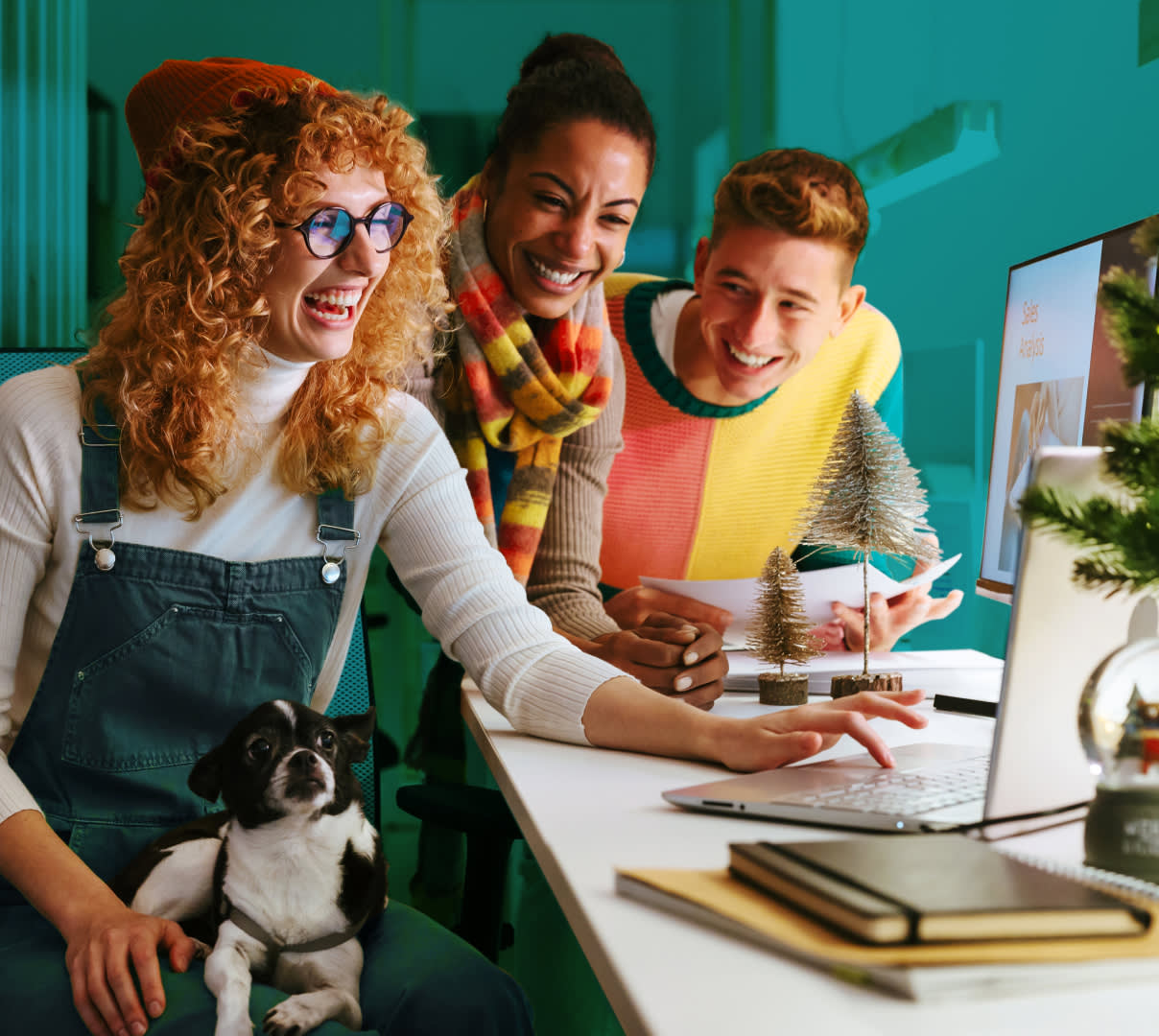 Coworkers huddled around a desk having fun