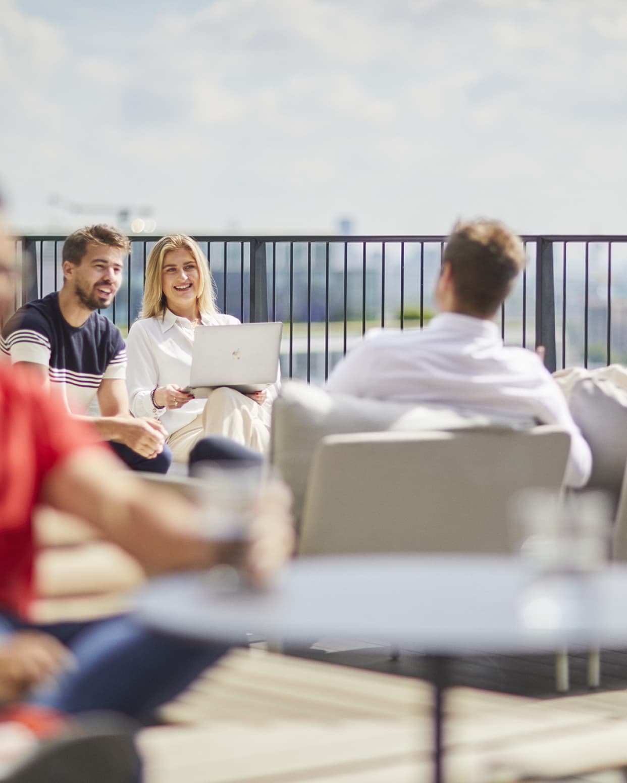 group talking on an outside urban deck with laptops