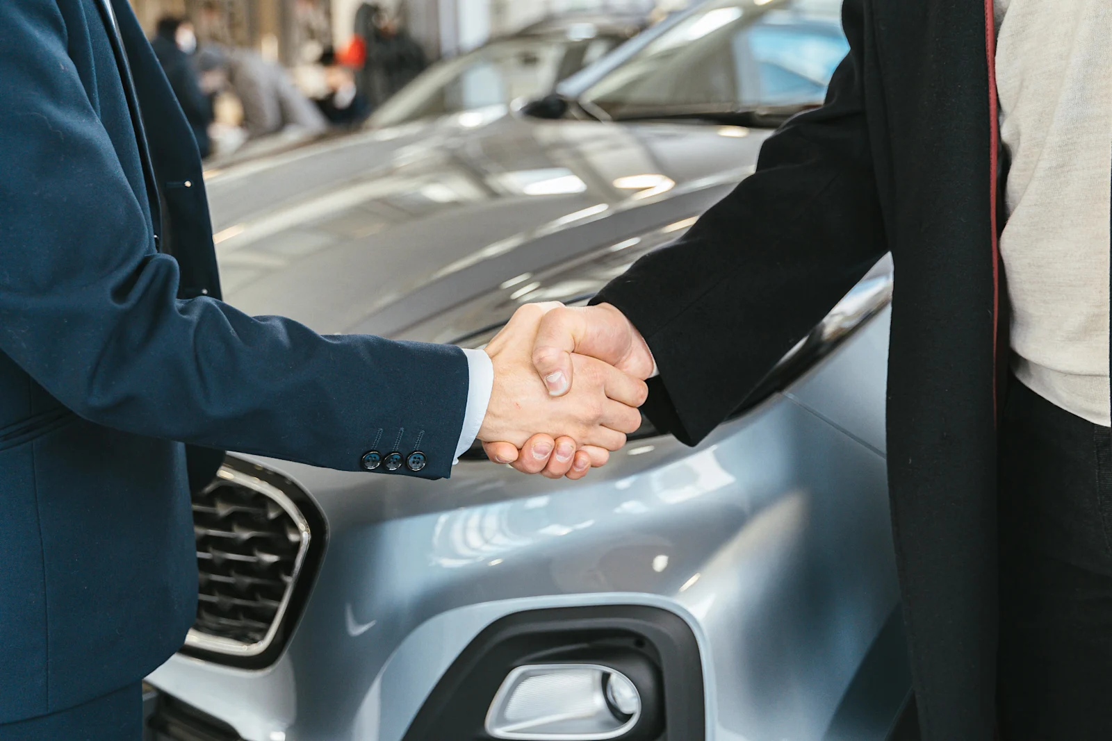 Shaking hands over car