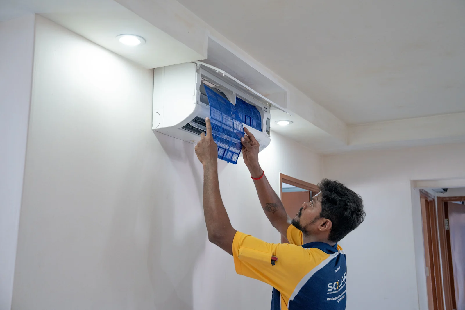 SACES staff servicing an aircon unit