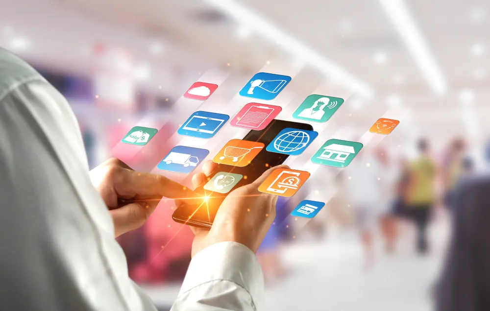 a person holding a smartphone displaying multiple commerce touchpoints