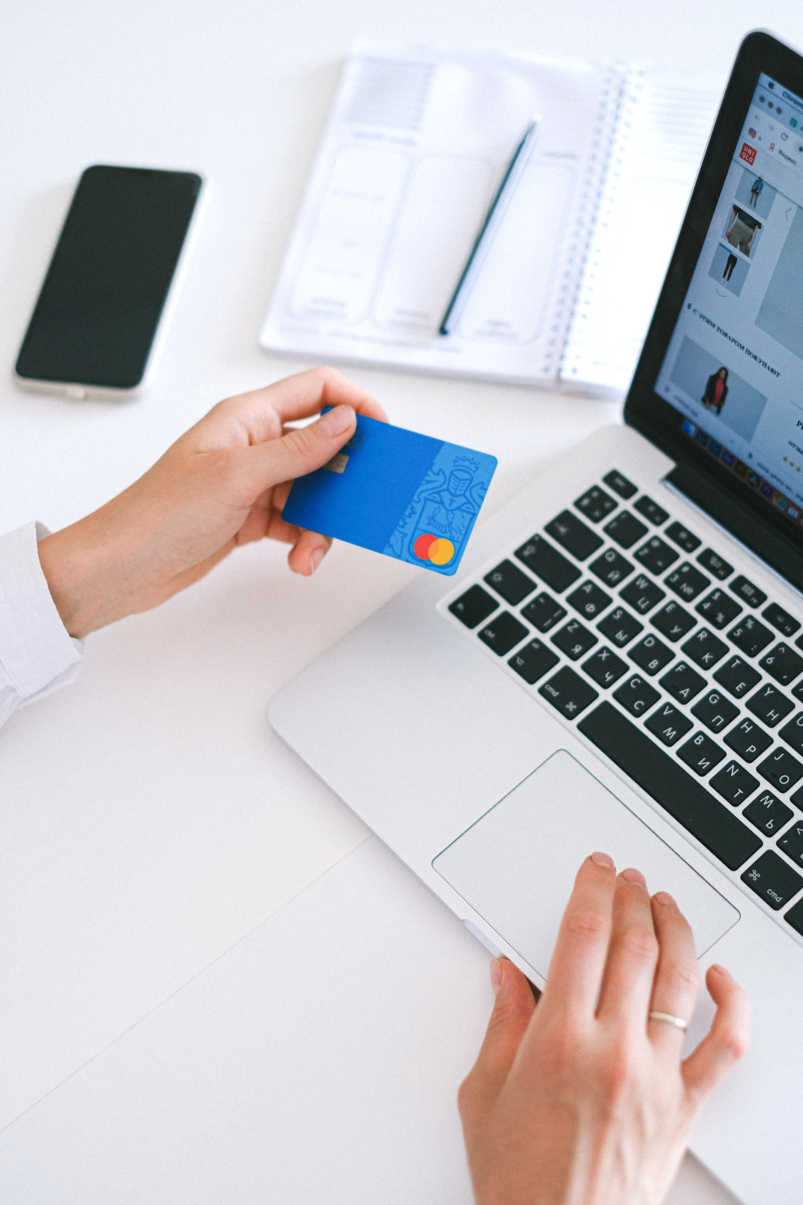 person holding bank card checking out online