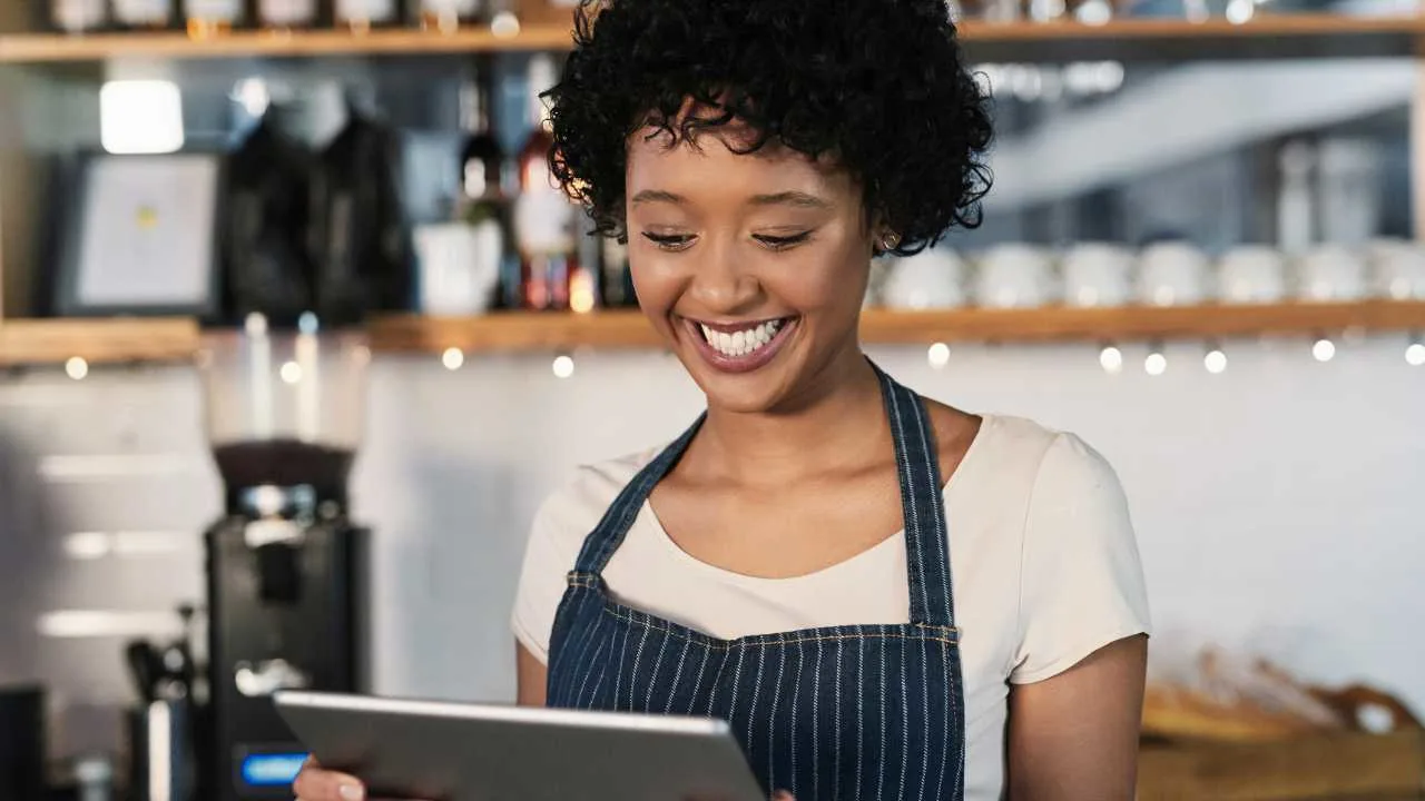  a smiling woman in an apron using a tablet