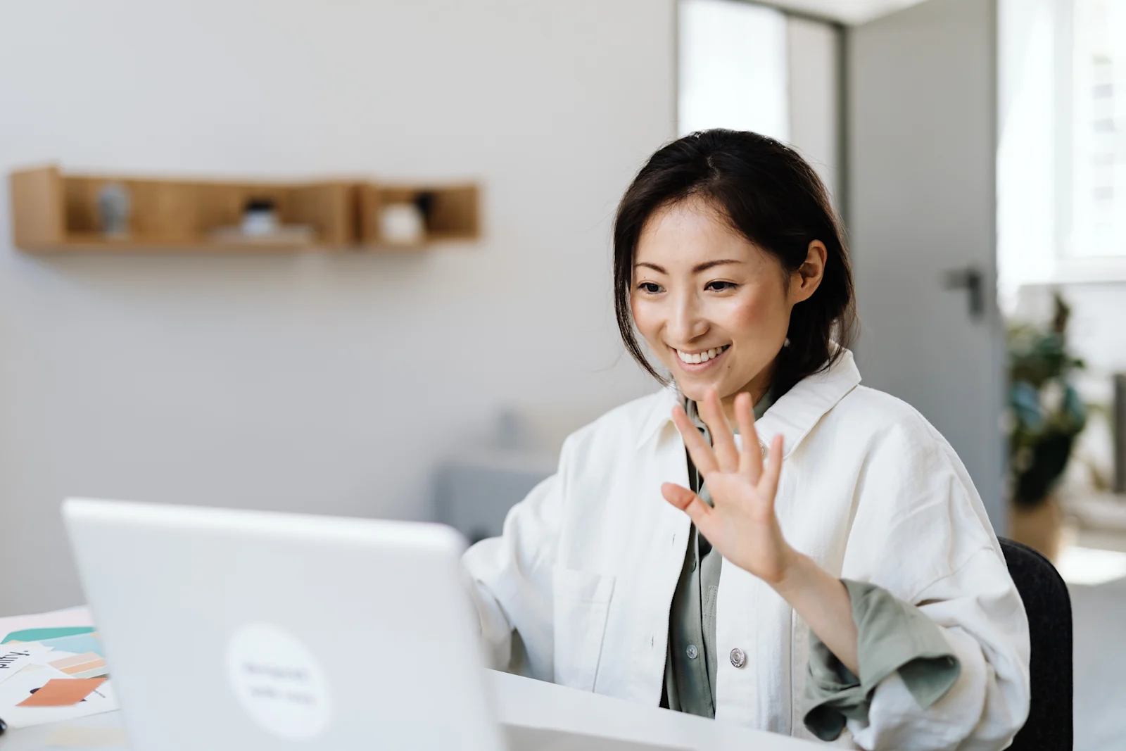 smiling woman waving during a video call
