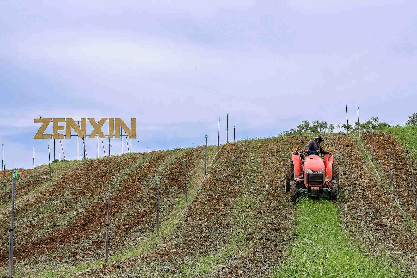 zenxin farm field with tractor and large zenxin sign in background