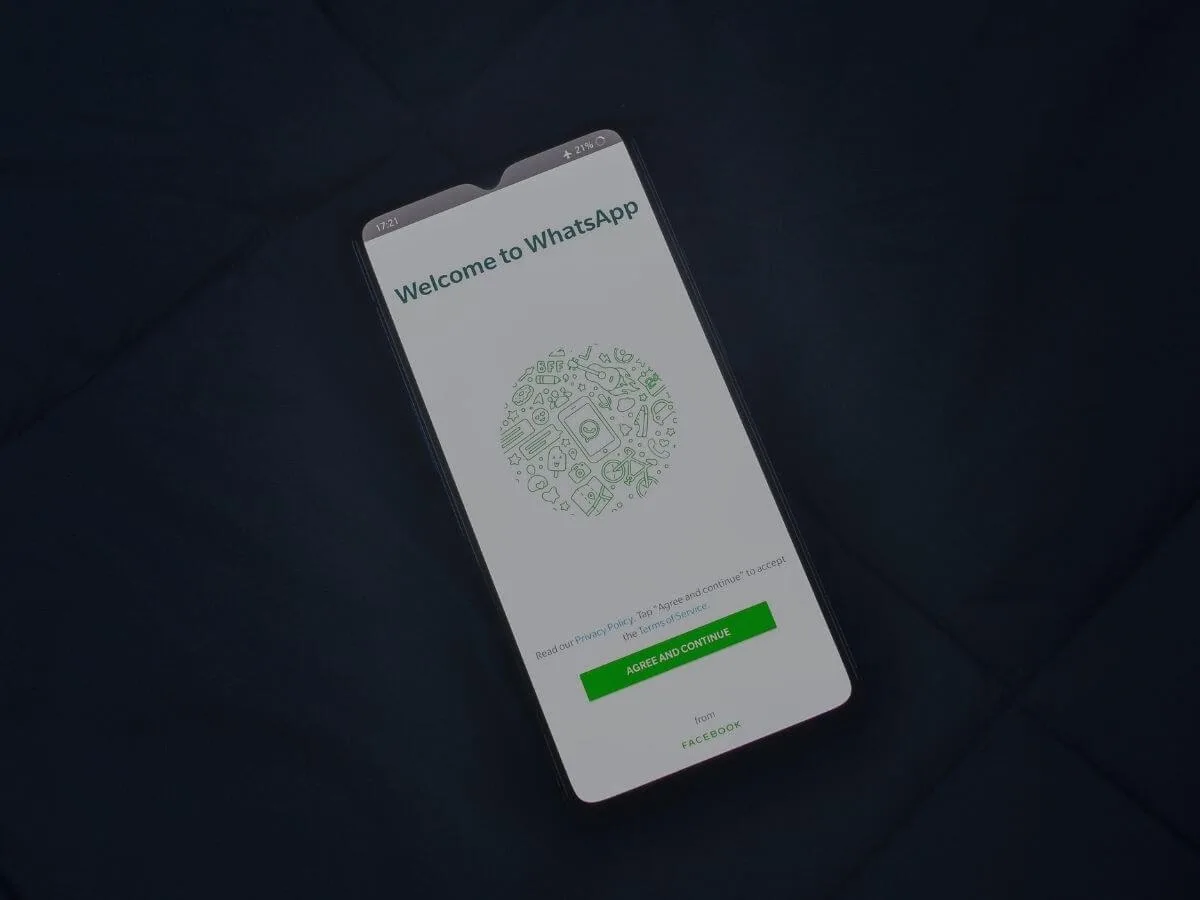 phone screen showing whatsapp welcome page with agree button