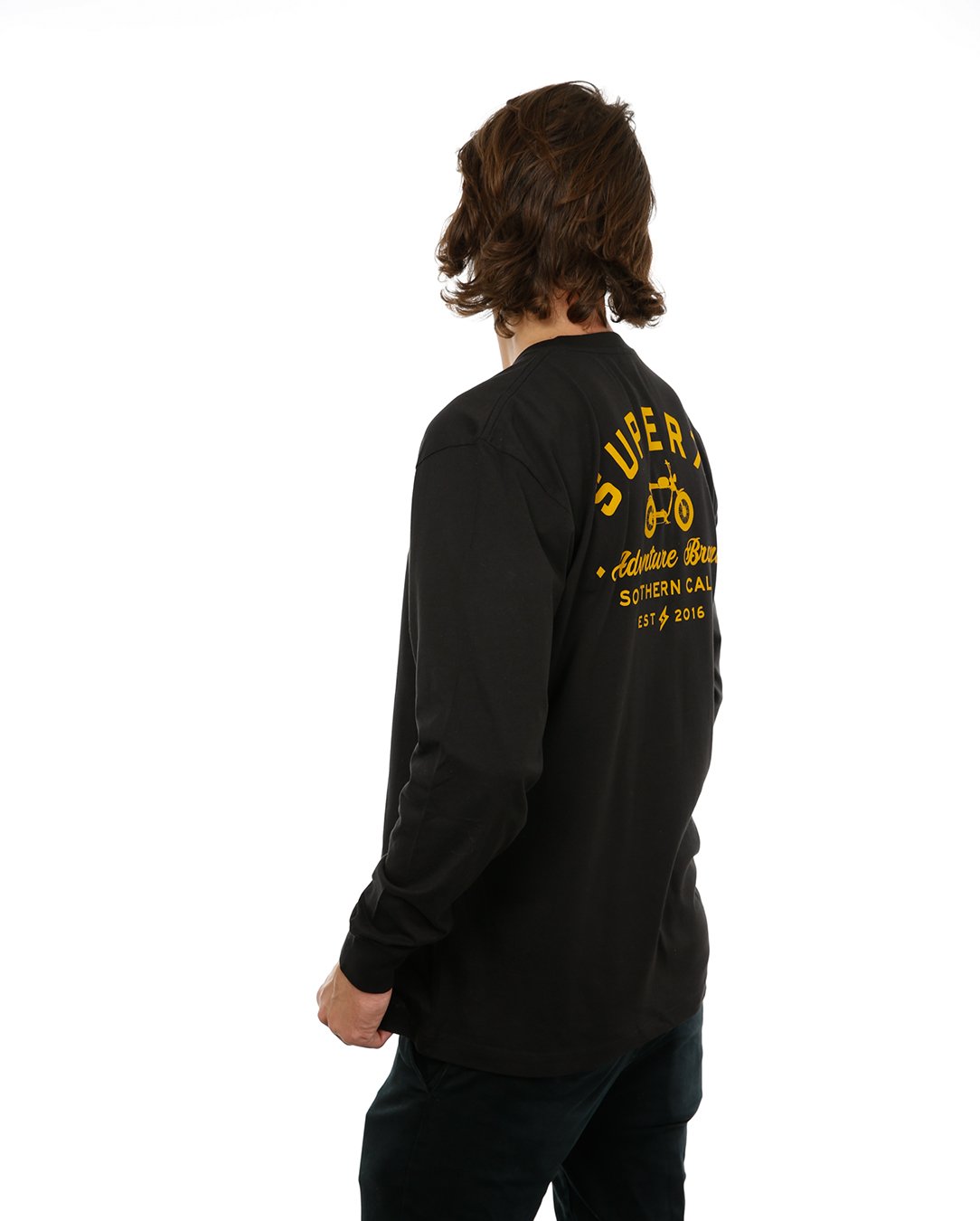 Side view of female model in Black Adventure Long Sleeve T-Shirt on white background.