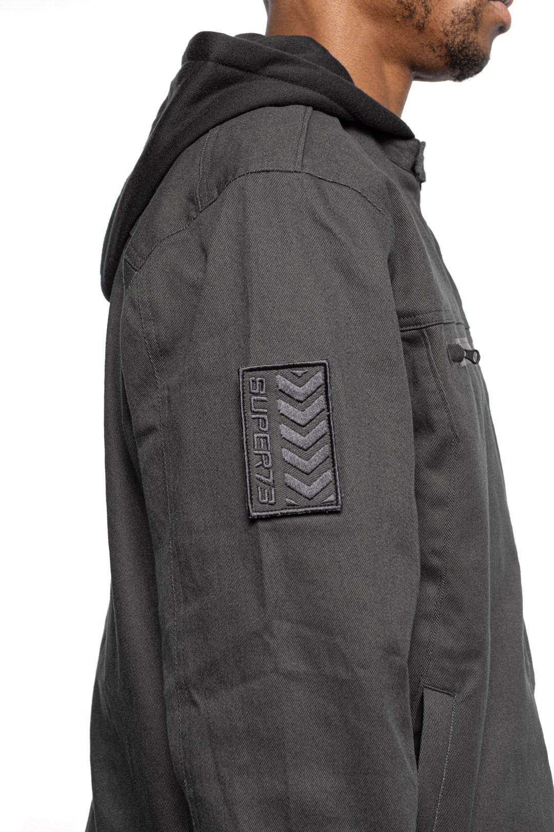 Side sleeve detail view of Male model wearing Chisel Hooded Jacket in gravel colorway.